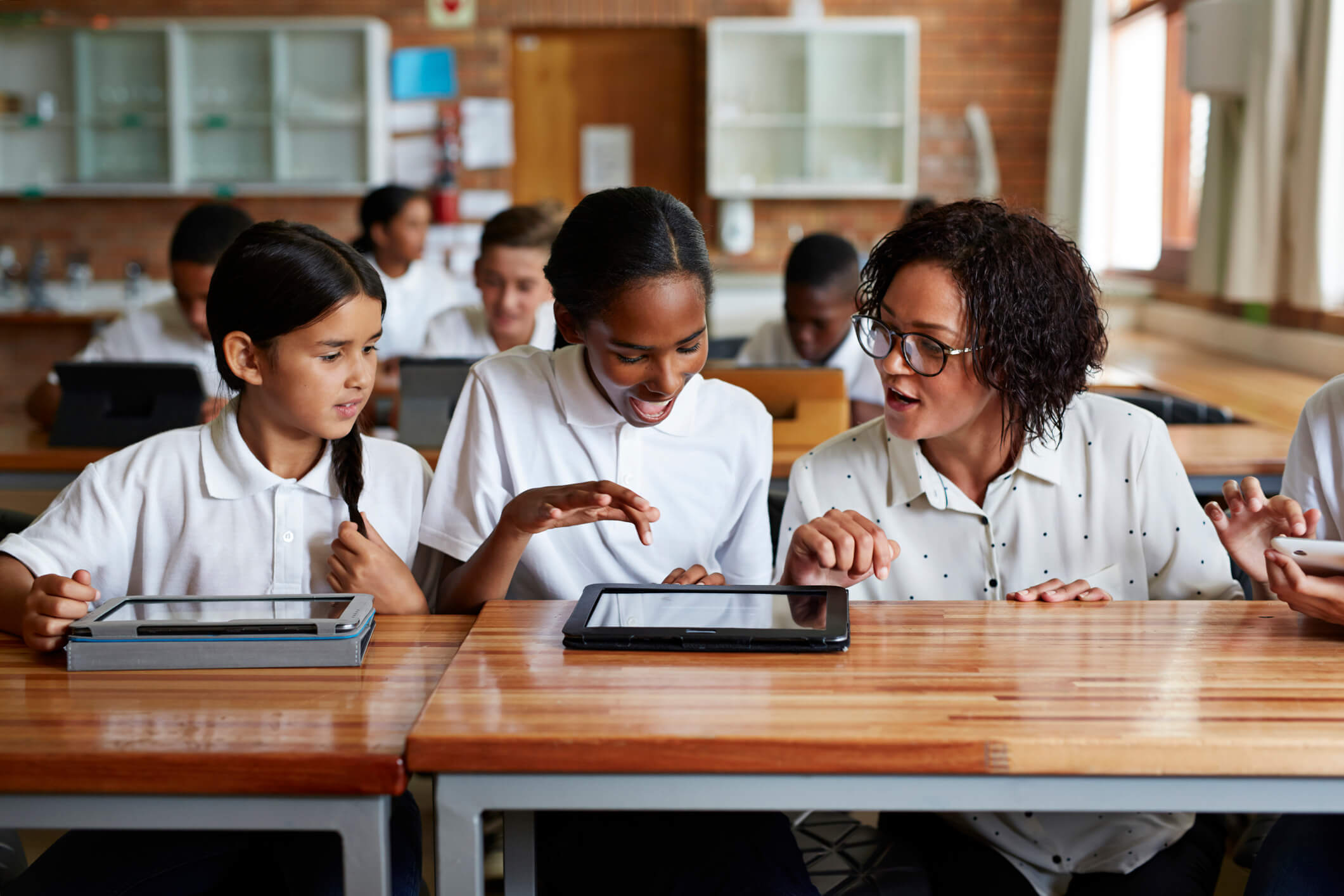 Three girl students working together on a digital project in class